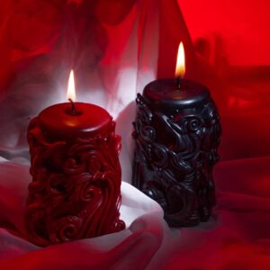 Kaksi kynttilää vierekkäin, Rouge ja Obsidian, mystisessä punaisessa valossa.